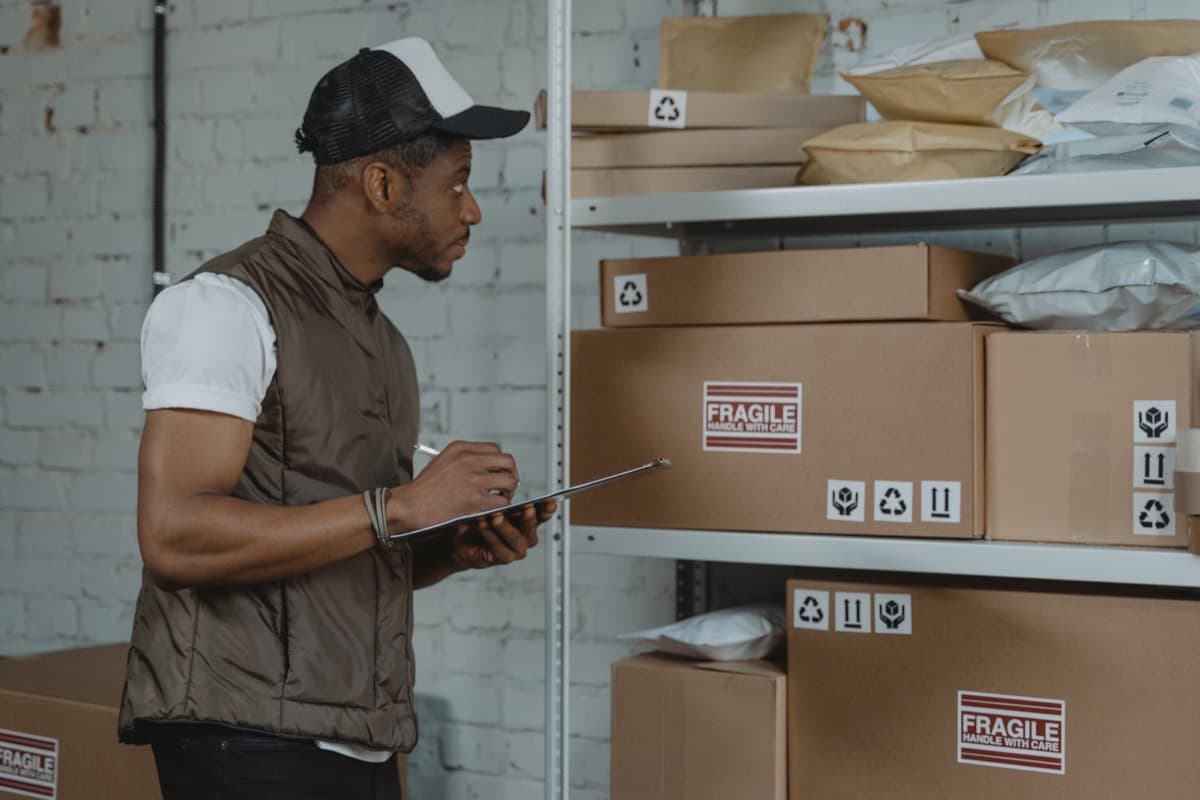 A warehouse worker checking parcels on shelves with a tablet